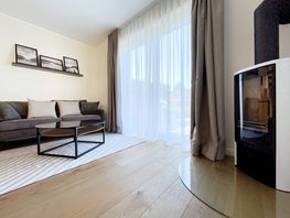 Wohnraum mit grauer Couch, Glastisch und Kamin im Ostsee-Domizil Ferienhaus Hohwacht